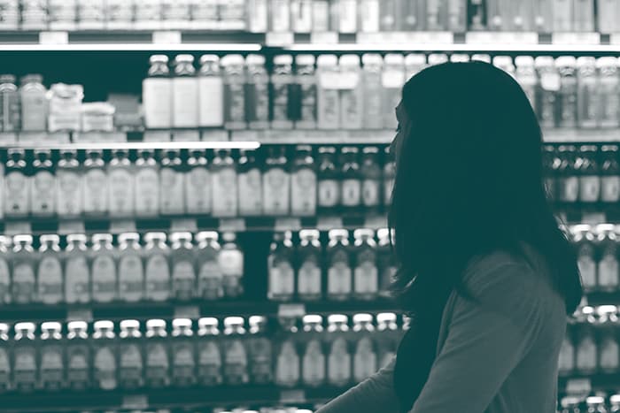 une femme avec un caddie dans un rayon de magasin